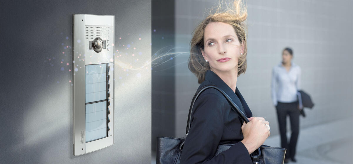 Une dame regarde la platine de rue qui sécurise sa propriété